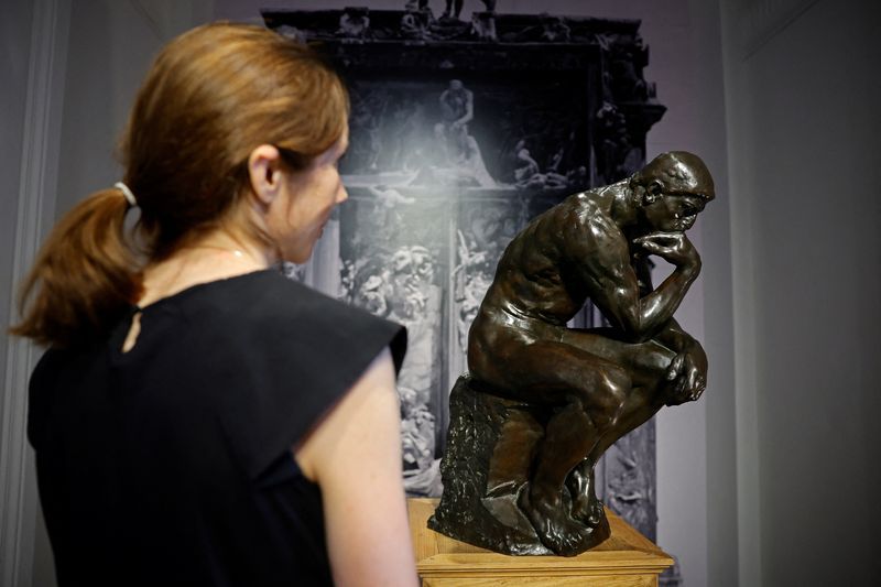 Archive image of a woman in front of a posthumous cast of "The Thinker" (circa 1928) by French sculptor Auguste Rodin (1840-1917) displayed prior to auction at Christie's auction house in Paris, France.  June 27, 2022. REUTERS/Sarah Meyssonnier/File