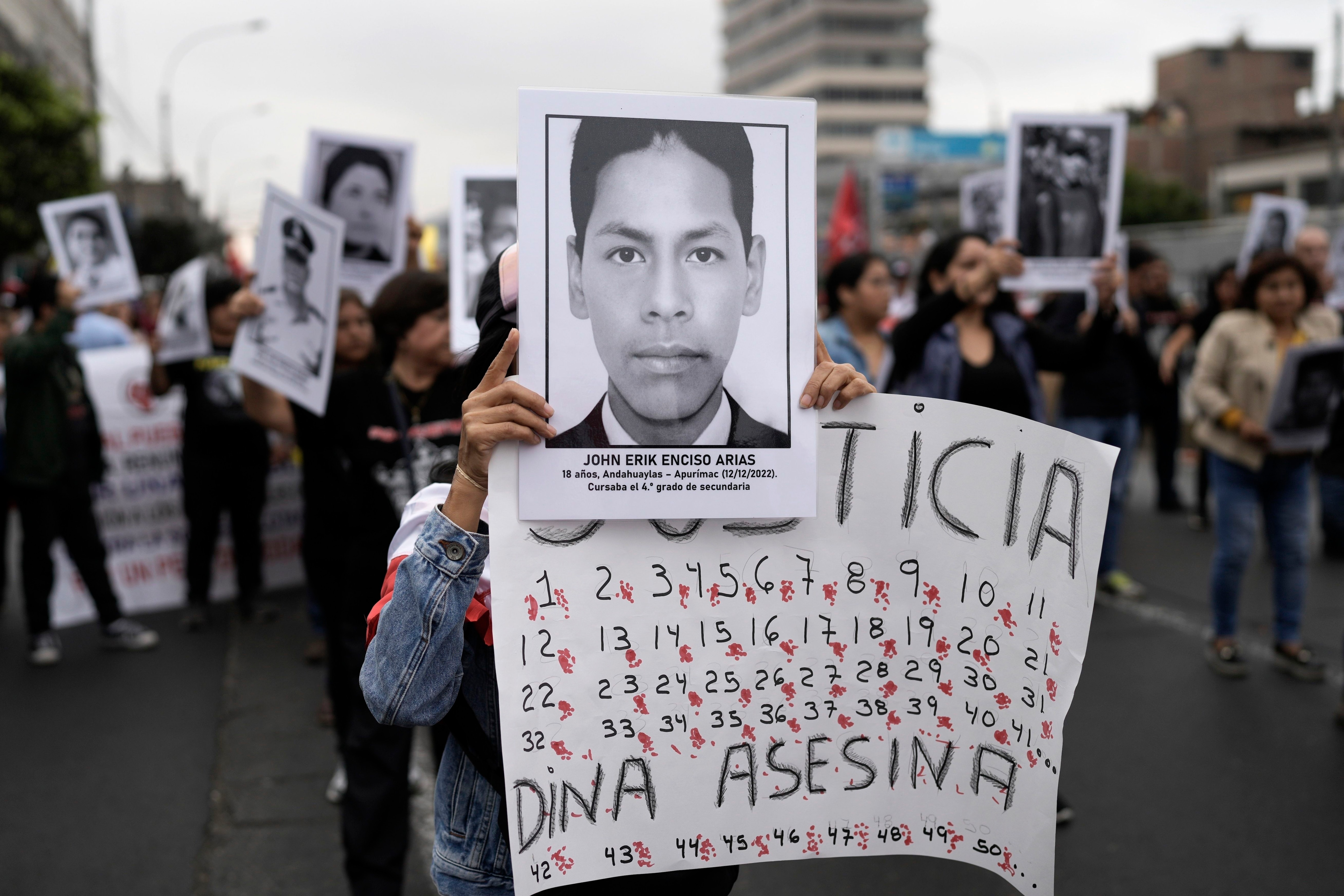 Displaying signs with photos of victims of police violence, protesters march through downtown Lima, Peru, Wednesday, July 19, 2023. The protest demands immediate electoral advancement from Peruvian President Dina Boluarte, as well as justice for those killed in the demonstrations that followed the dismissal of Pedro Castillo as president.  (AP Photo/Rodrigo Abd)
