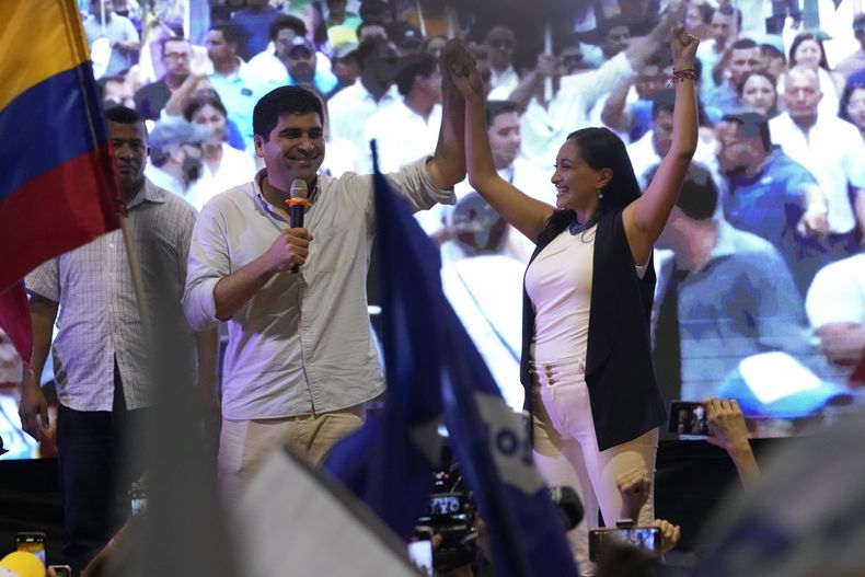 Presidential candidate Otto Sonnenholzner raises the hand of his running mate Erika Paredes during a campaign event in Guayaquil, Ecuador, Thursday, Aug. 17, 2023. (AP Photo/Martín Mejía)
