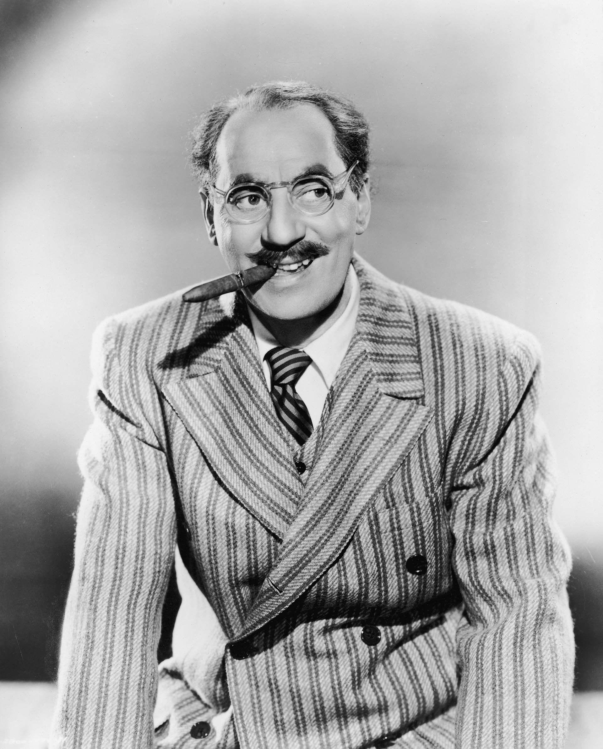 Groucho Marx, with his characteristic cigar but without the makeup mustache, in 1945 (Photo by Pictorial Parade/Getty Images)