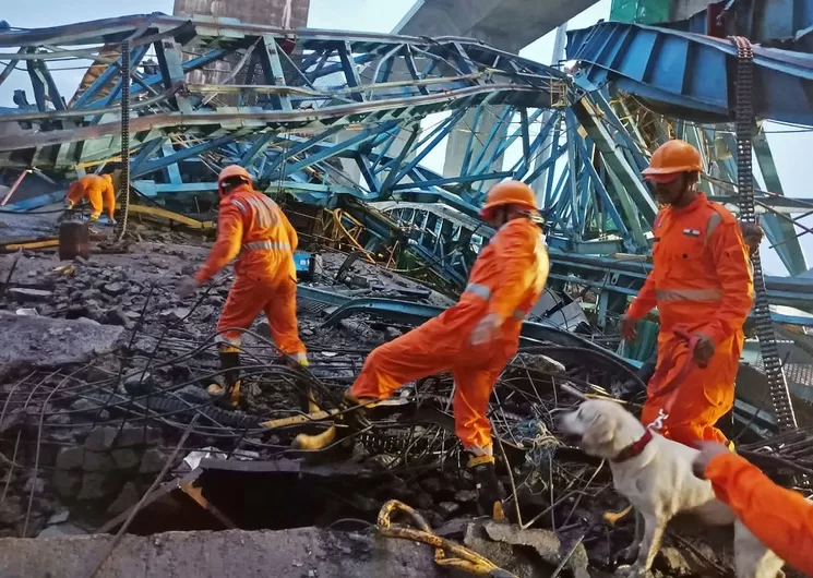 Trabajadores inspeccionan el sitio de una autopista Samruddhi en construcción donde una grúa se derrumbó sobre la losa del puente en el distrito de Thane del estado de Maharashtra en la India. Foto Afp