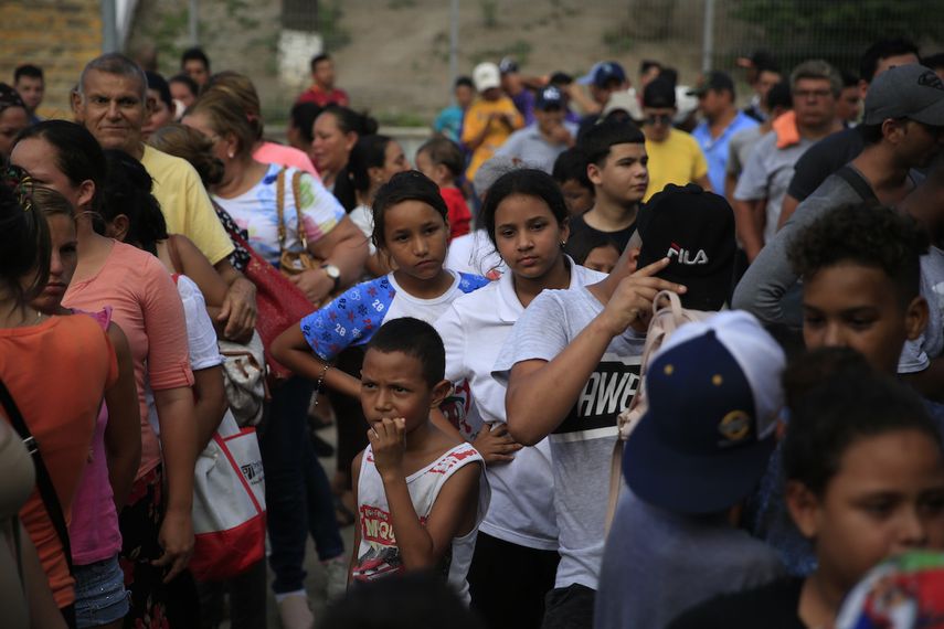 Migrants from different countries, including Honduras, Cuba, Venezuela and Nicaragua, line up to receive food donated by volunteers from the United States, at the foot of a bridge that crosses to Brownsville, Texas, in the center of Matamoros, in the state of Tamaulipas, Mexico. 
