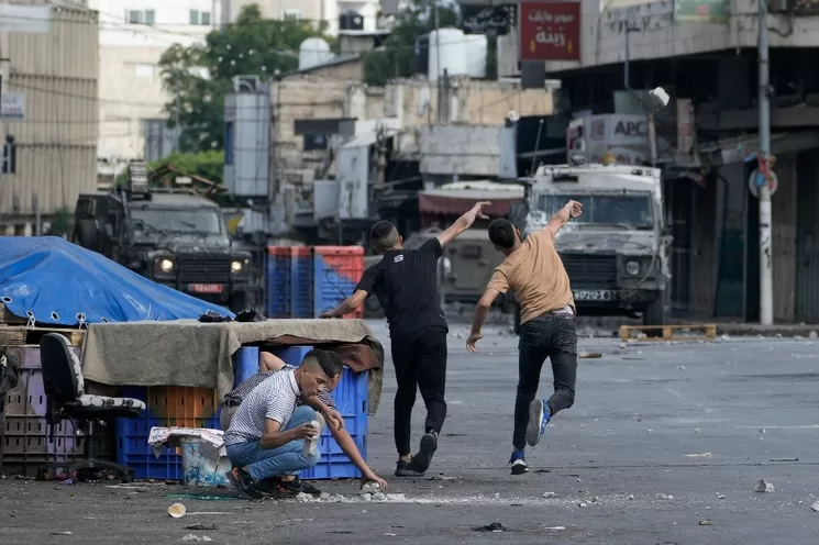 En imagen de archivo, palestinos chocan con las fuerzas de seguridad israelíes durante una incursión militar en la ciudad cisjordana de Nablus. Foto Ap