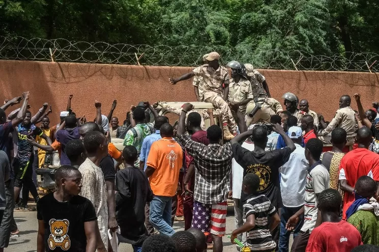 Nigerinos animan a las tropas de Níger mientras se reúnen frente a la embajada de Francia en Niamey, la capital de ese país, durante una manifestación de apoyo a los militares golpistas que derrocaron al presidente electo Mohamed Bazoum, antes de que fueran dispersados con gases lacrimógenos, el 30 de julio de 2023. Foto Afp