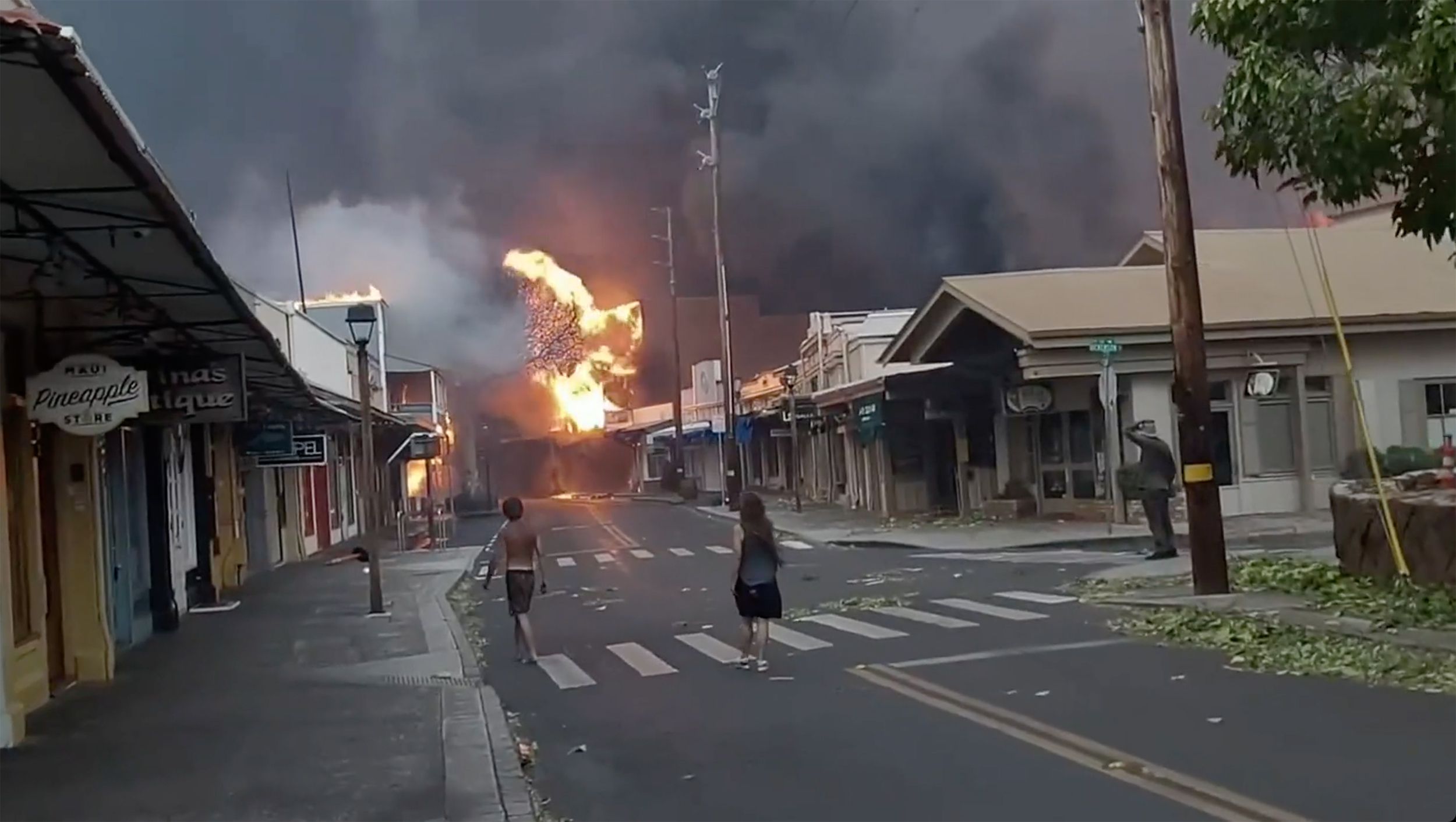 People watch as smoke and flames from the wildfires billow onto Front Street in downtown Lahaina, Maui, Hawaii, on Aug. 8, 2023. (Alan Dickar via AP)