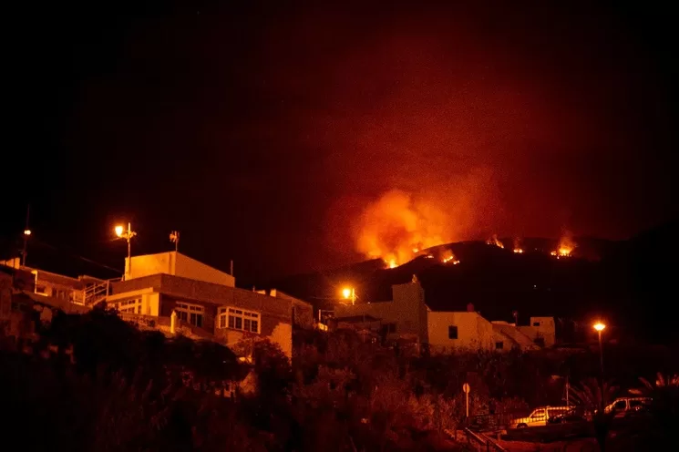 Incendio forestal en las colinas sobre las casas, en el valle de Guimar en la isla canaria de Tenerife. Foto Afp
