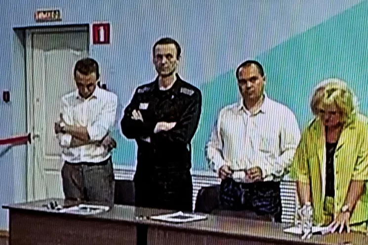 Una pantalla muestra al opositor ruso Alexei Navalny (segundo de la izquierda), ya encarcelado, mientras escucha su veredicto sobre una serie de cargos de extremismo en la colonia penal IK-6, una prisión de máxima seguridad a unos 250 kilómetros al este de Moscú. Foto Afp