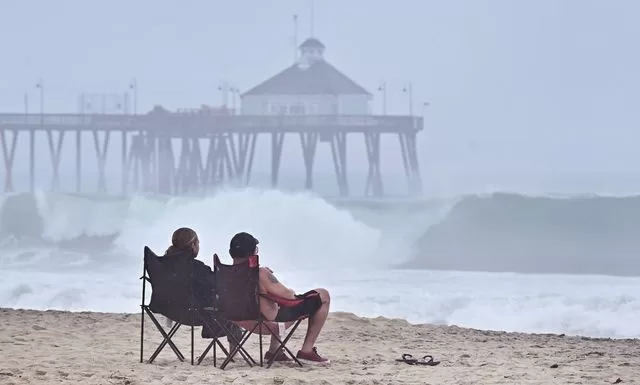 Una pareja observa las olas al sur de California, en medio de la tormenta tropical ‘Hilary’. Foto Afp