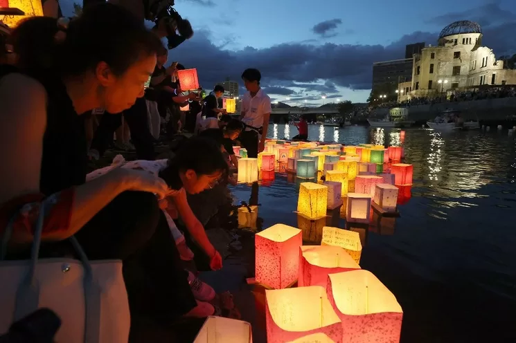 Residentes colocan linternas de papel en el río Motoyasu, junto al Salón de Promoción Industrial de la prefectura de Hiroshima, comúnmente conocido como el domo de la bomba atómica, para recordar el 78 aniversario del primer ataque con armas de destrucción masiva en el mundo, perpetrado por Estados Unidos en dicha ciudad japonesa. Foto Afp/Jiji Press