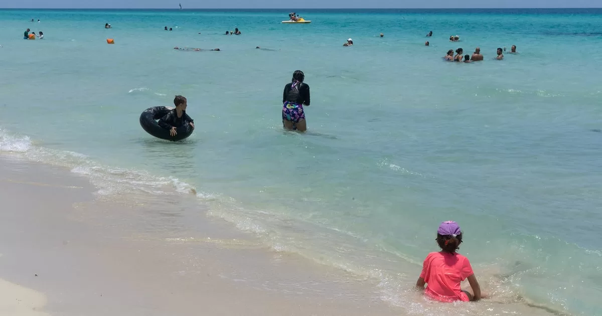 Why do Cubans bathe with clothes on the beach?
