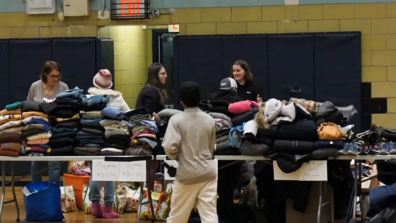 Migrants go to event at clothing distribution school

