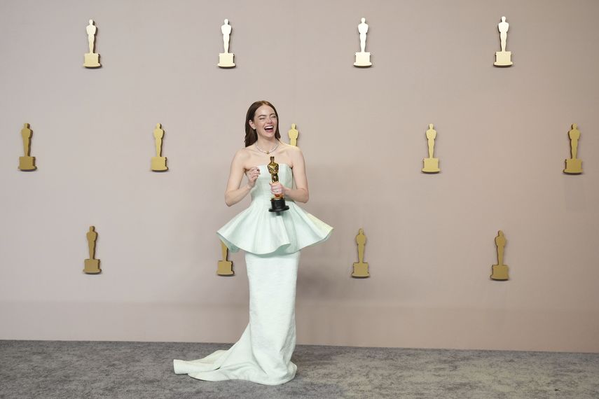 Emma Stone poses in the press room with the award for Best Actress in a Leading Role for Poor Things at the Oscars on March 10, 2024 at the Dolby Theater in Los Angeles.