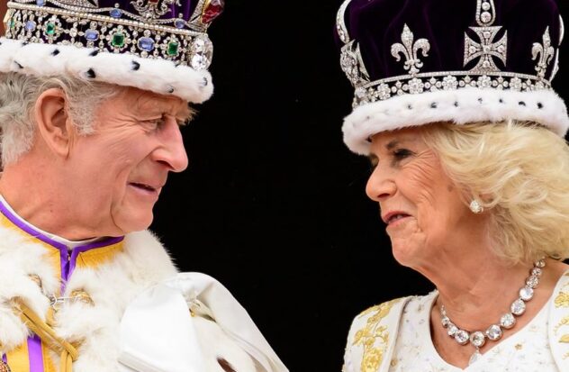 Britain's King Charles III looks at Queen Camilla as they stand on the balcony of Buckingham Palace in London after their coronations on May 6, 2023.