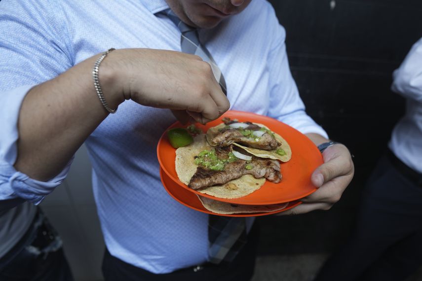 A customer squeezes a lemon into his tacos at the Tacos El Califa de León taco restaurant in Mexico City, Wednesday, May 15, 2024. Tacos El Califa de León is the first taco shop to receive a Michelin star.