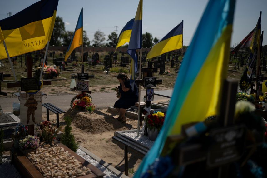 A woman cries at the grave of her son, who died in the war, as Ukrainians celebrate Independence Day in Kharkiv, Ukraine, Thursday, August 24, 2023.