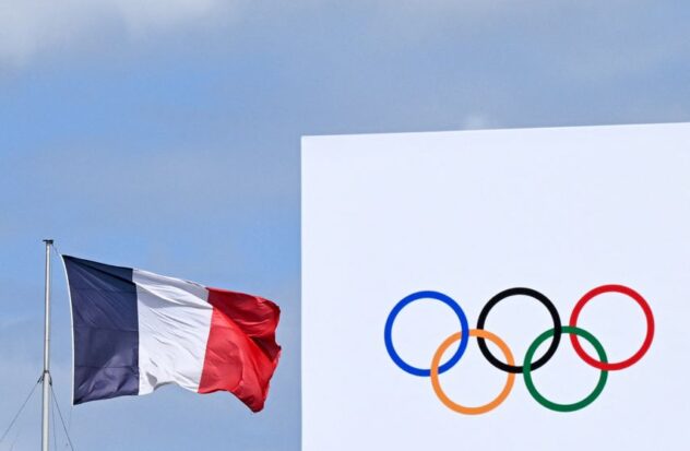 The French national flag is displayed near the Olympic rings at La Concorde in Paris, July 23, 2024, ahead of the Paris 2024 Olympic Games.