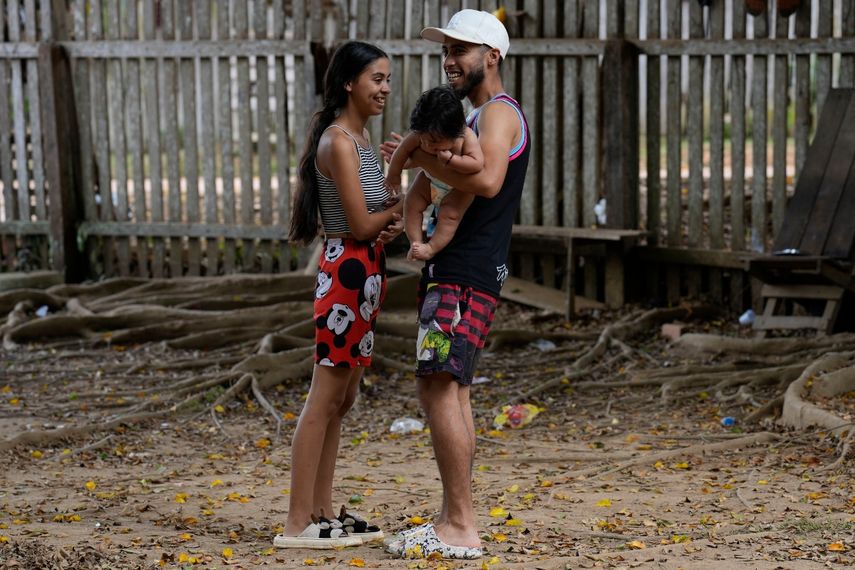 Venezuelans Alexandra Villarreal (left) and Alexander Martinez hold their daughter Alexandra in their arms on the grounds of a migrant shelter in Assis, Brazil, June 20, 2024. Martinez said she will stay as long as necessary to get more money and, perhaps in a year, leave for Houston, where she has family.