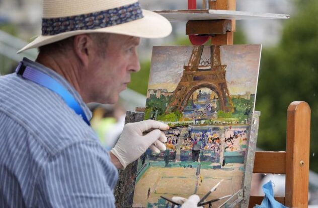 Peter Spens of London, England, paints at the Eiffel Tower Stadium during a beach volleyball match at the 2024 Summer Olympics, Saturday, July 27.