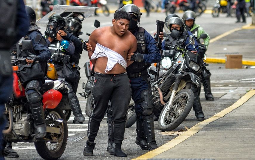 Members of the Bolivarian National Police detain a man during an opposition demonstration in the Chacao neighborhood of Caracas on July 30, 2024. Security forces fired tear gas and rubber bullets at protesters and an NGO said 11 people have been killed and dozens more have been killed.  